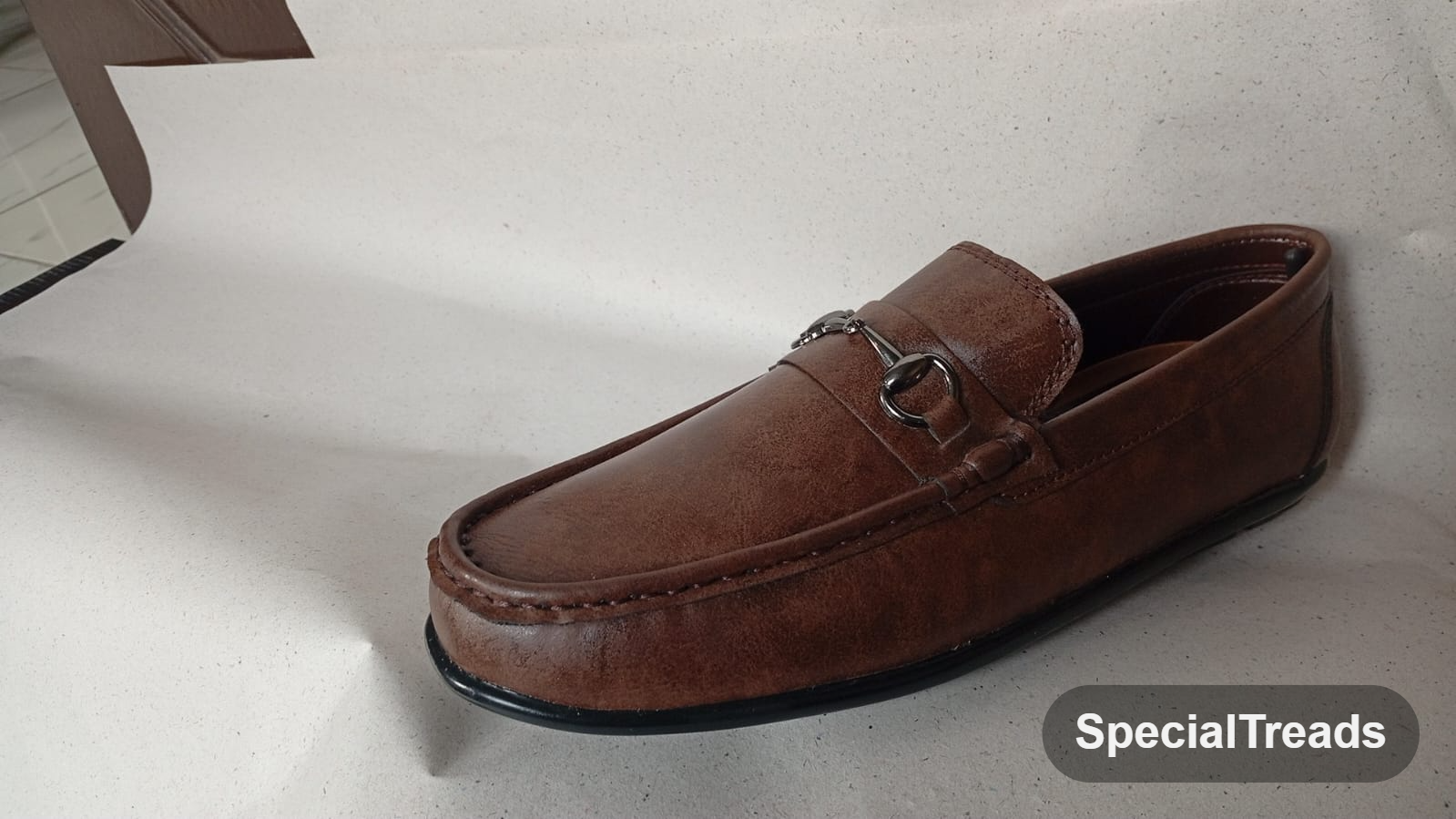 Brown horsebit loafer side profile view
