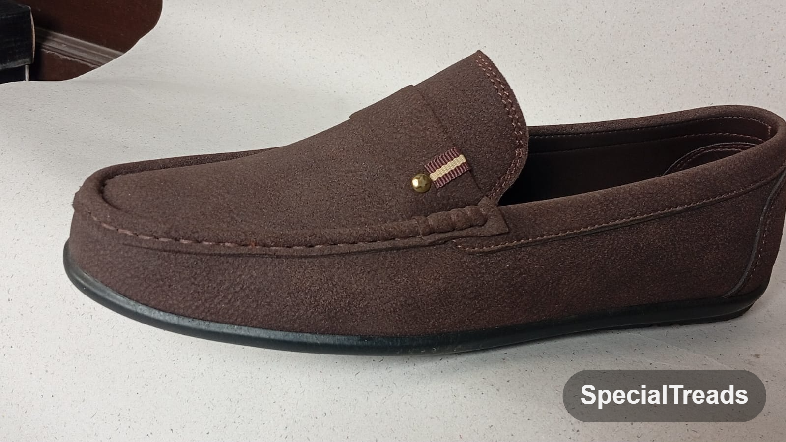 Dark brown suede slip-on loafer with gold pin accent