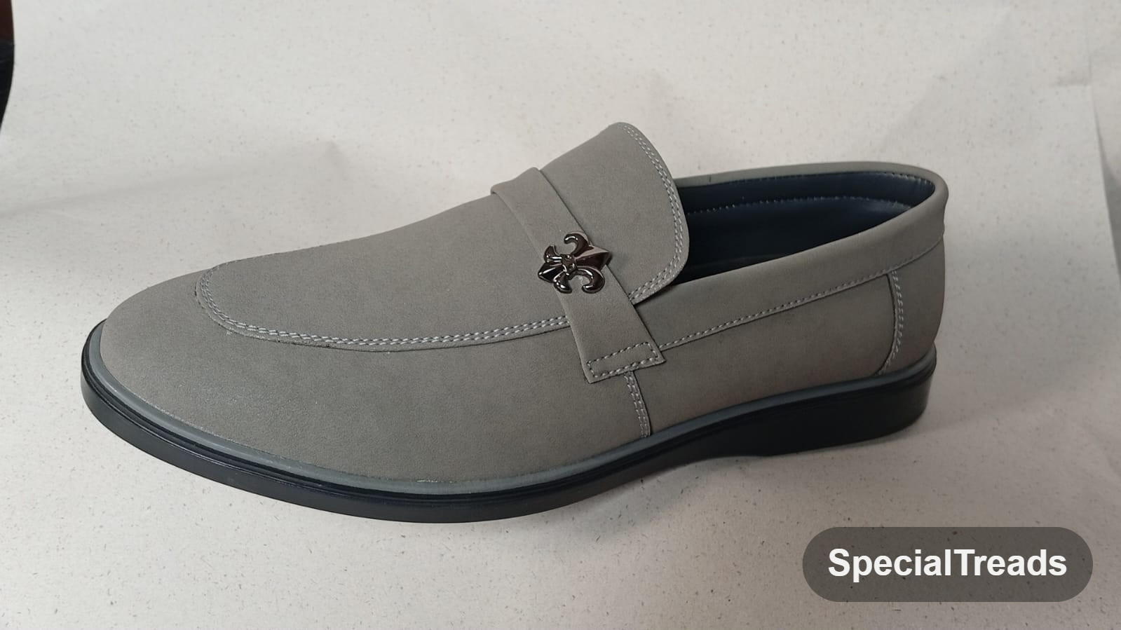Light grey suede loafer with fleur-de-lis metal emblem