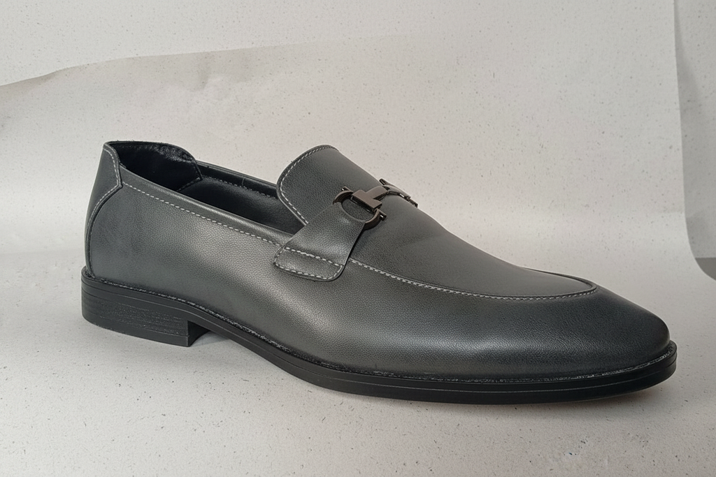 Grey leather horsebit loafer side profile on white background